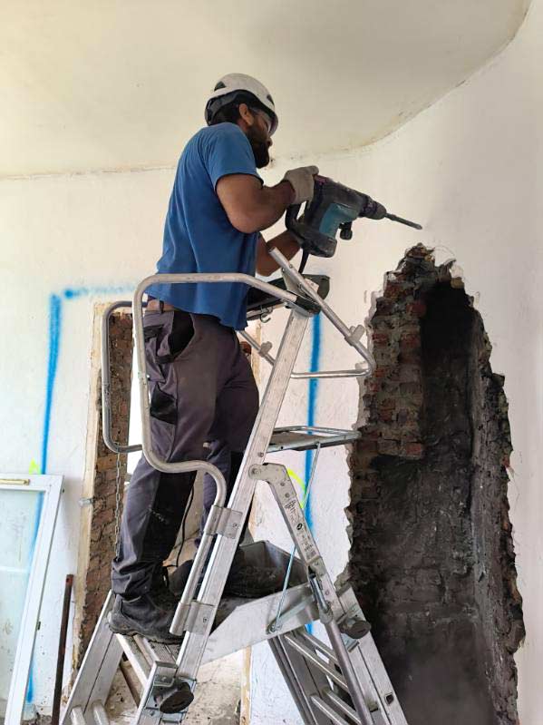 Un salarié en train de détruire une cloison